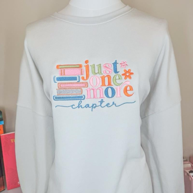 Just One More Chapter Sweater - White Pullover with Colorful Book Design and "Chapter" Text - Womenswear